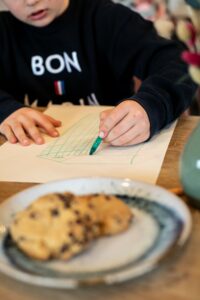 Le Pass'Heure Salon de Thé à Savonnières Enfant à table devant un cookie maison au salon de thé Le Pass’heure.